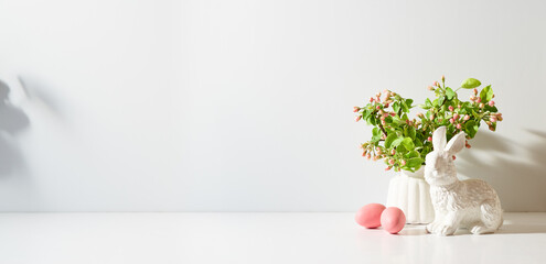 Spring flowers in a vase and easter eggs on a light background. Easter background with copy space