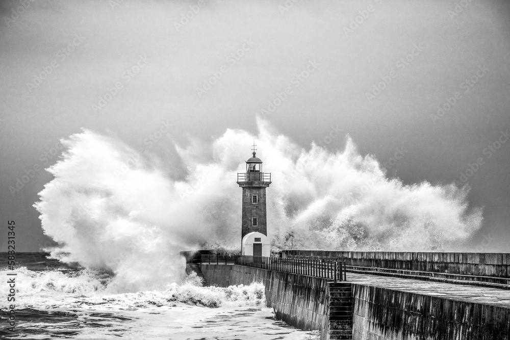 Waves crashing on lighthouse on the beach. Farolim de Felgueiras, Porto, Portugal