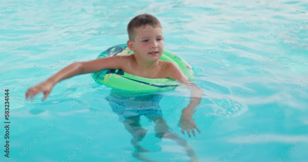 Funny happy child boy in swimming pool on inflatable rubber circle ring Funny happy child boy in swimming pool on inflatable rubber circle ring