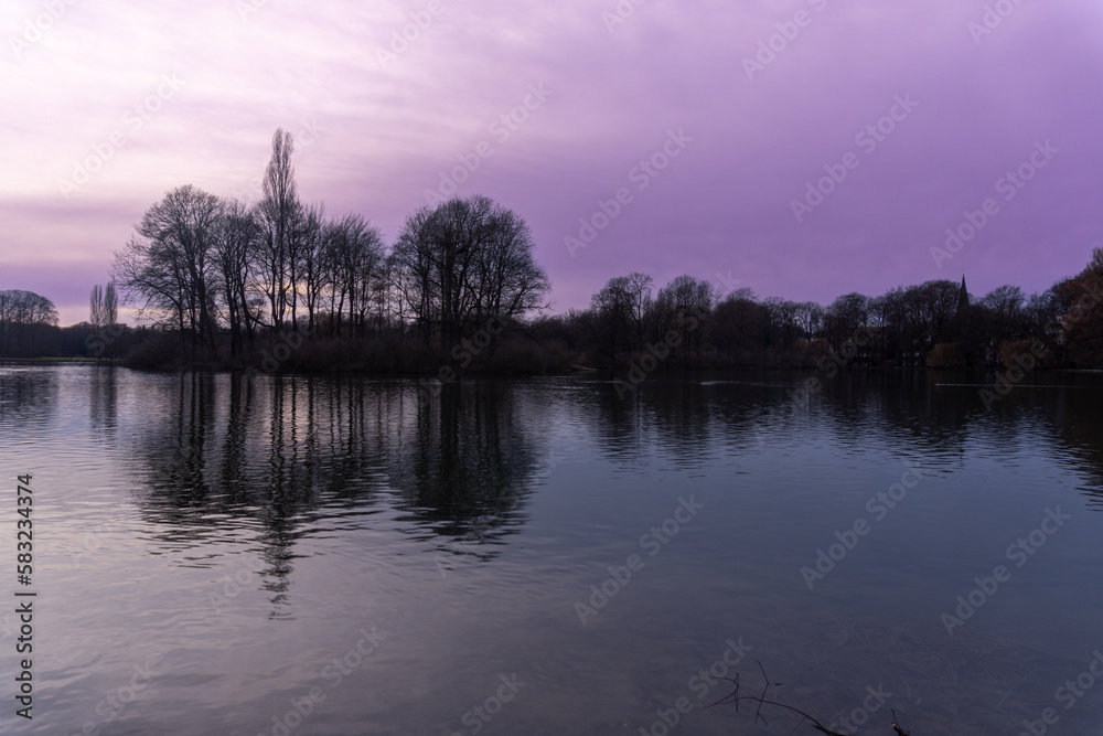 Park in the center of Munich, at sunset with the reflection of trees in the water Park in the center of Munich, at sunset with the reflection of trees in the water