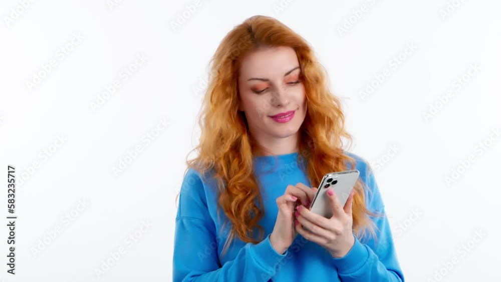 Surprised young woman pointing at mobile phone surprised expression, shocked emotional. Wow! Lady amazed and excited with smart phone. Oh my god! Indoor studio shot isolated on white background Surprised young woman pointing at mobile phone surprised expression, shocked emotional. Wow! Lady amazed and excited with smart phone. Oh my god! Indoor studio shot isolated on white background