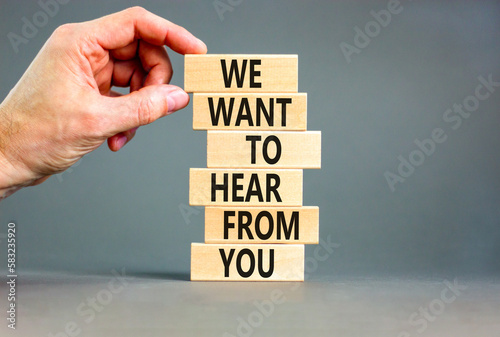 Support symbol. Concept words We want to hear from you on wooden blocks. Beautiful grey table grey background. Businessman hand. Business support we want to hear from you concept. Copy space.