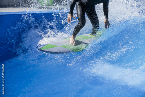 Canvas Print A surfer dressed in his black neoprene suit raising foam in the waves of a swimm