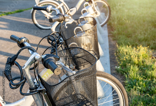 Bicycles for rent in the city park. Row of bicycles on the parking space. Urban background. Close up.  Summer, spring activities. Bikes for new lifestyle