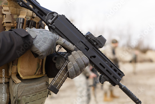 Ukrainian soldier training with modern 9mm submachine gun on military shooting range outdoor photo