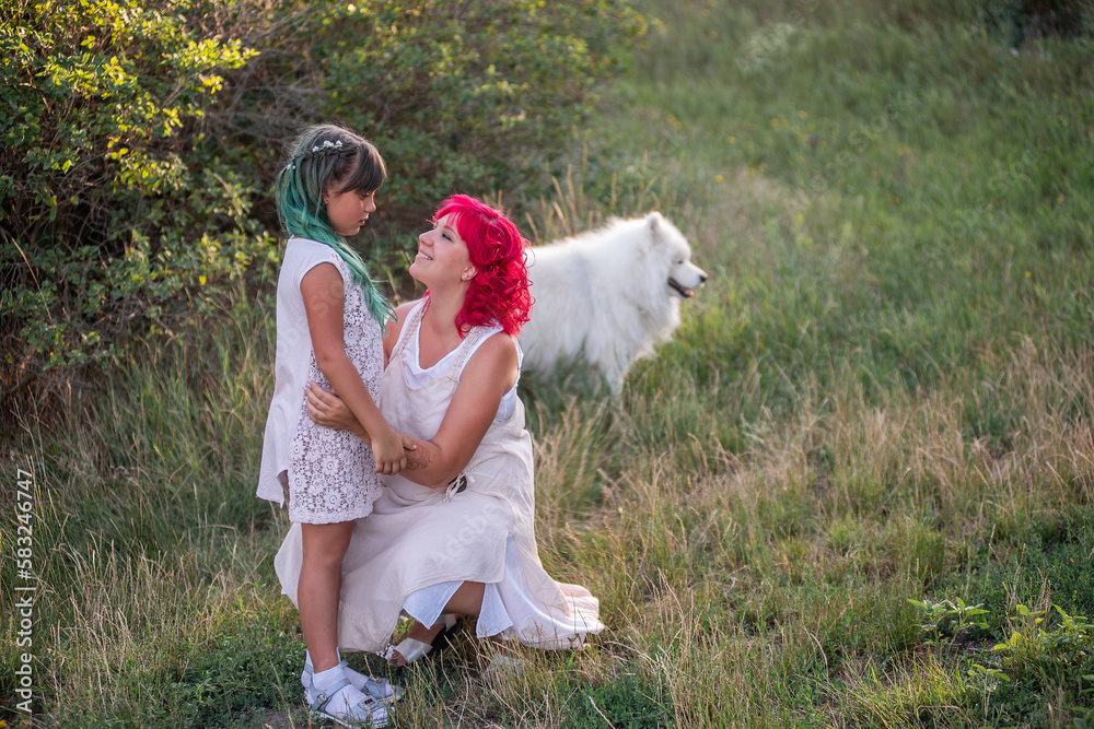 Bright, diversity, extraordinary mother daughter hugging in forest. Woman has pink hair, girl green Bright, diversity, extraordinary mother daughter hugging in forest. Woman has pink hair, girl green