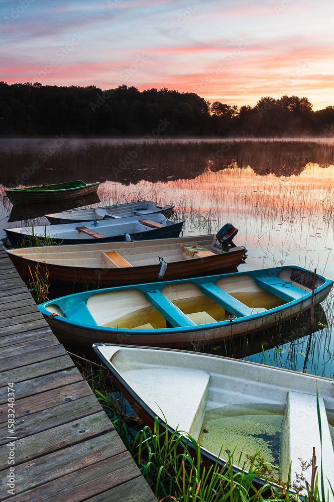 Obraz premium Row of boats at jetty during sunrise