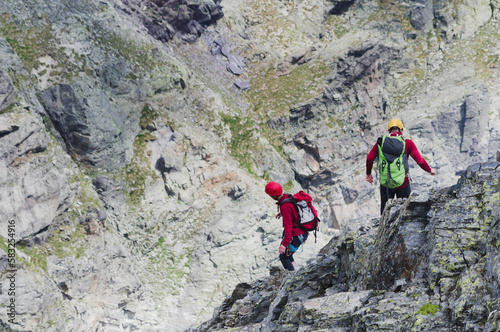 climbers descending a steep rocky ridge