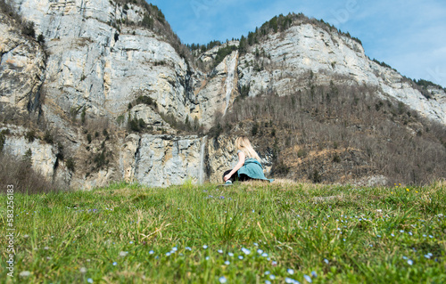 blonde girl looking up to the massive Seerenbach waterfalls at Walensee photo