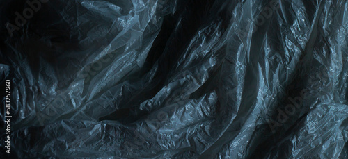 Dark gray plastic wrap background. Crumpled wrinkled plastic cellophane. Texture overlay effect template