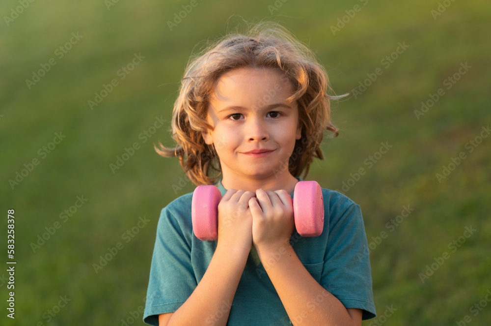 Sport activities at leisure with children. Blonde boy holding dumbbells. Sports exercises for children. Funny child lifting the dumbbells. Sport activities at leisure with children. Blonde boy holding dumbbells. Sports exercises for children. Funny child lifting the dumbbells.