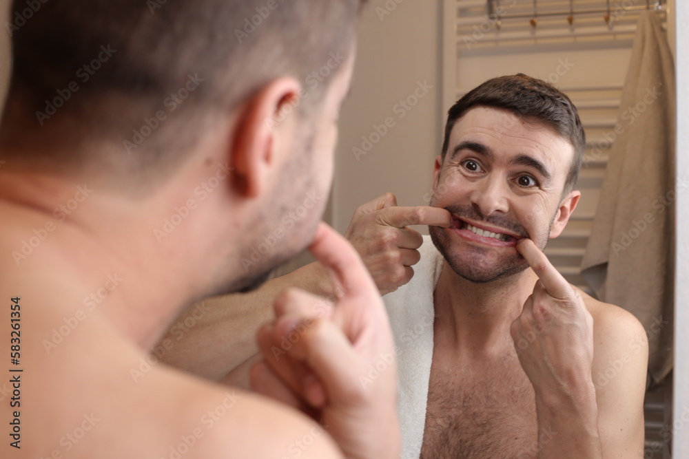 Fototapeta premium Man forcing a smile in the bathroom mirror