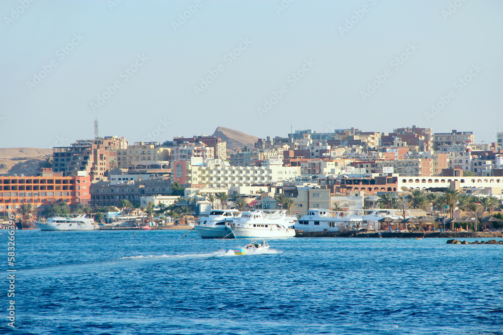 View of embankment of Hurghada with moored yachts, ships and beautiful mosque