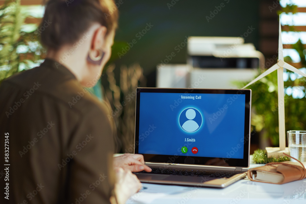 Seen from behind modern woman with laptop having video chat Seen from behind modern woman with laptop having video chat