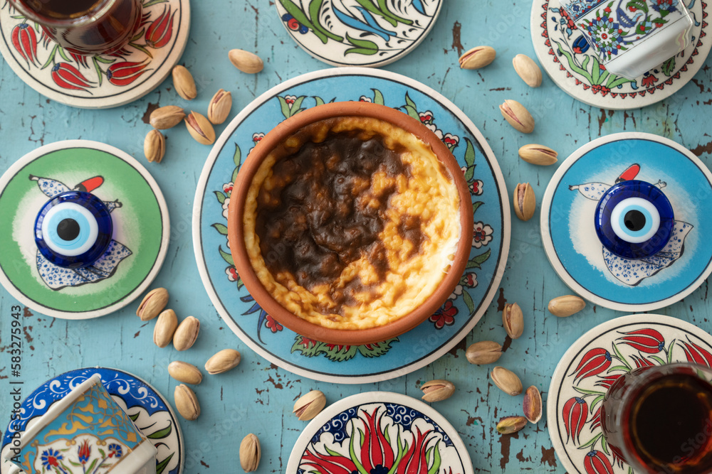 Photograph of Rice Pudding (Turkish Sutlac) in Ottoman Tile Turkish Coffee Cup and Turkish Tea Concept, Uskudar Istanbul, Turkey	