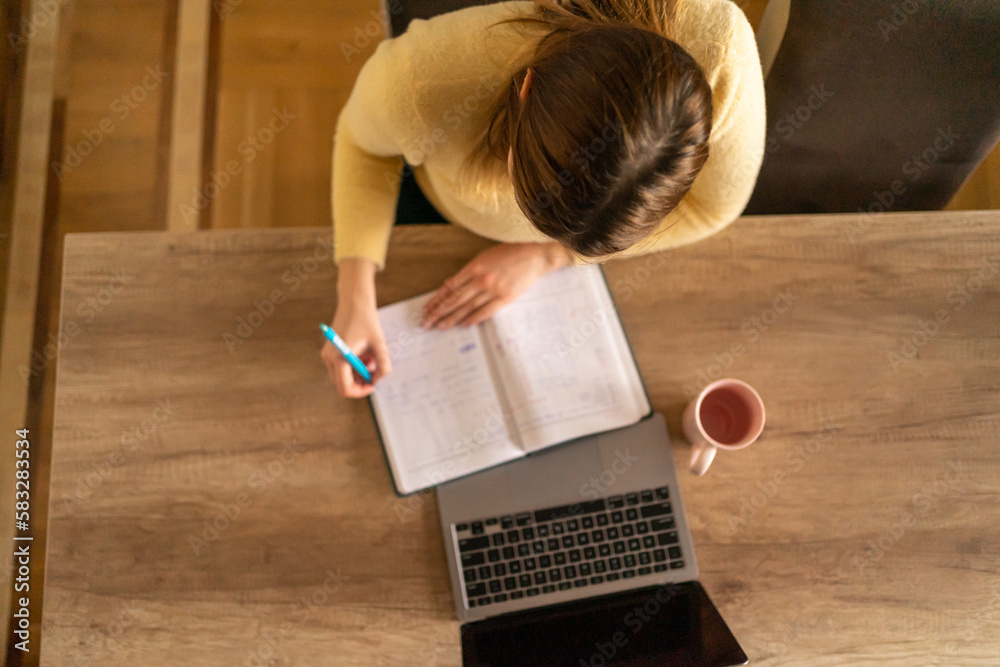 Young woman working from home, photo from above.
Young woman working from home, photo from above.