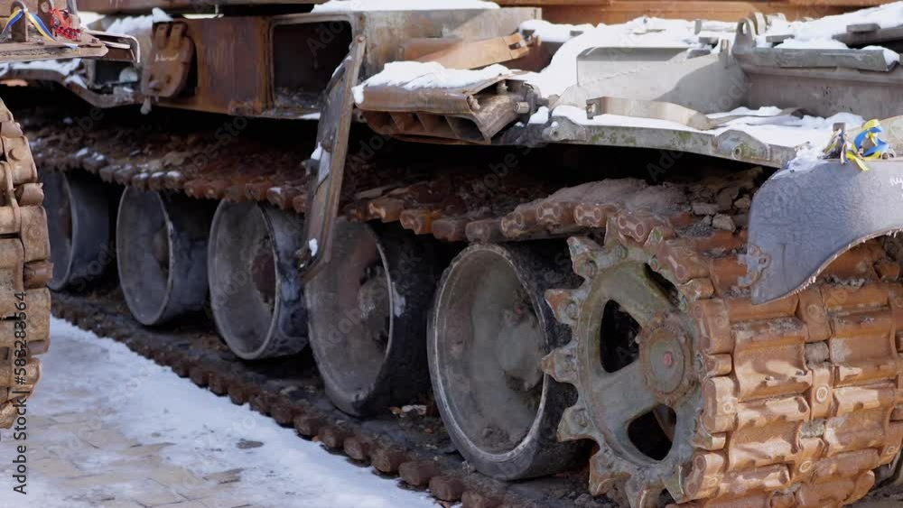 Burnt, Snow Covered Rusty Tracks of a Wrecked Military Tank of Russian Occupiers. Side view. Close-up. Remains of burnt military equipment. Russian invasion of Ukraine. War. Combat, battle. Kyiv. Burnt, Snow Covered Rusty Tracks of a Wrecked Military Tank of Russian Occupiers. Side view. Close-up. Remains of burnt military equipment. Russian invasion of Ukraine. War. Combat, battle. Kyiv.