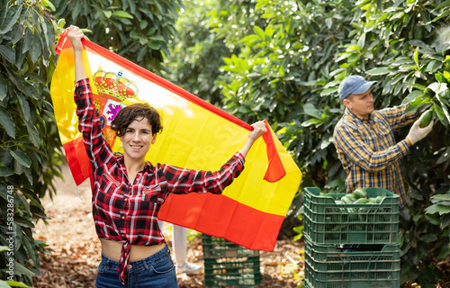 Smiling girl football fan waving Spanish flag during avocado harvest