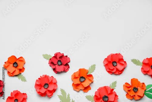 Paper poppy flowers with leaves on grey background