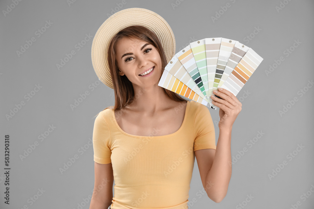 Beautiful woman with paint color palettes on grey background Beautiful woman with paint color palettes on grey background