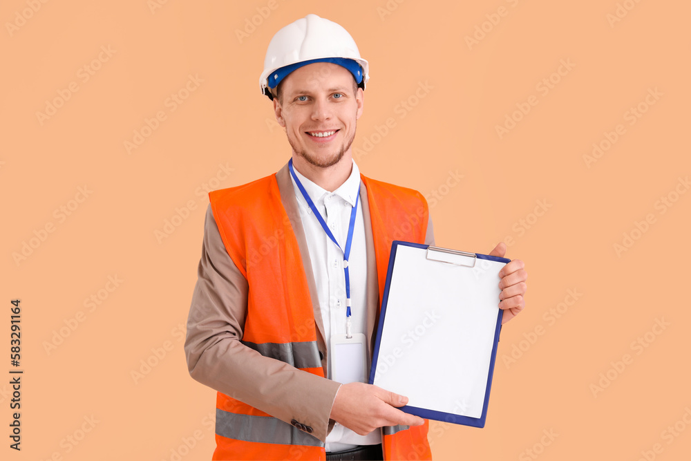 Male architect with clipboard on beige background Male architect with clipboard on beige background
