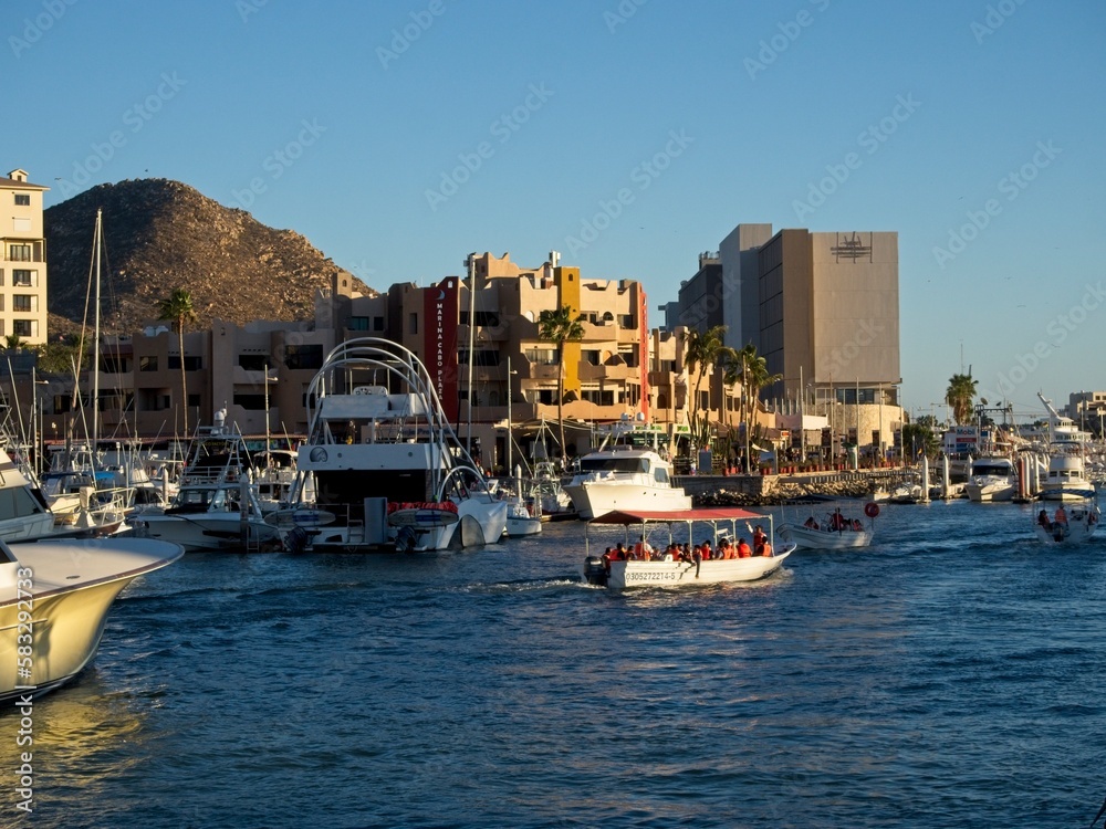 The marina of Cabo San Lucas is bustling with yachts andglass bottom boats buzzing to and from the upscale marina district out into the rough waters
