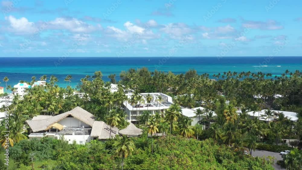 Tropical coastline with resorts, palm trees, caribbean sea and people having fun on beach. Travel destinations. Dominican Republic. Aerial view Tropical coastline with resorts, palm trees, caribbean sea and people having fun on beach. Travel destinations. Dominican Republic. Aerial view