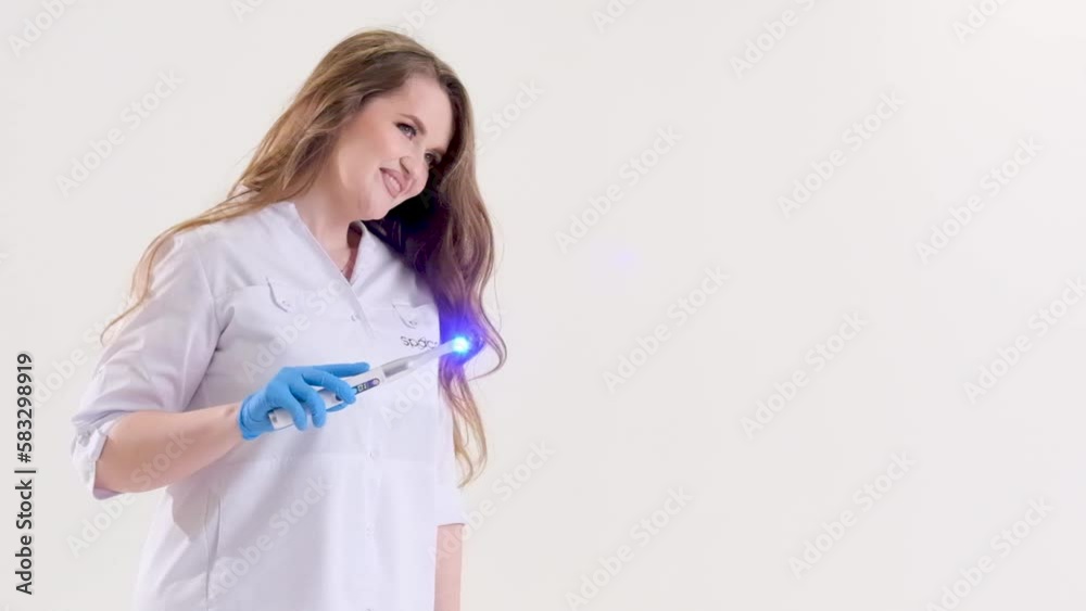 Photopolymer lamp a woman doctor like a Fairy waves lamp like a magic wand in a white suit on a white background conjures fascinates treats for children fairy tale Photopolymer lamp a woman doctor like a Fairy waves lamp like a magic wand in a white suit on a white background conjures fascinates treats for children fairy tale
