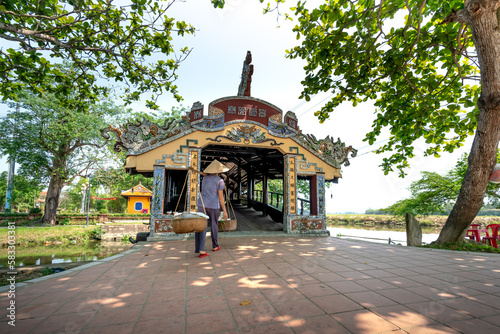 Charming model in traditional white ao dai by the ancient Thanh Toan tile bridge at Thanh Thuy Village, Hue city, Vietnam photo