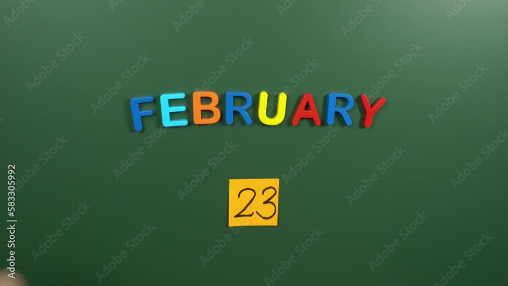 Hand sticking a sticker 23 February calendar day on school board. 23 date of February. Twenty third day of February. 23th date number. 23 day calendar. Twenty three date Hand sticking a sticker 23 February calendar day on school board. 23 date of February. Twenty third day of February. 23th date number. 23 day calendar. Twenty three date