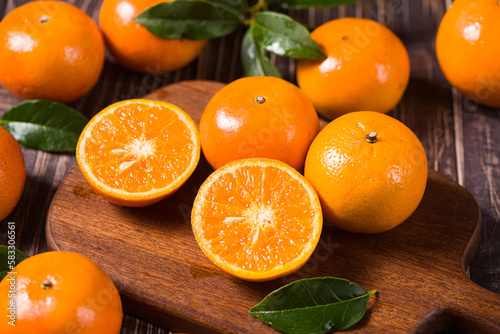 Fresh mandarin oranges or tangerines on wooden table. photo