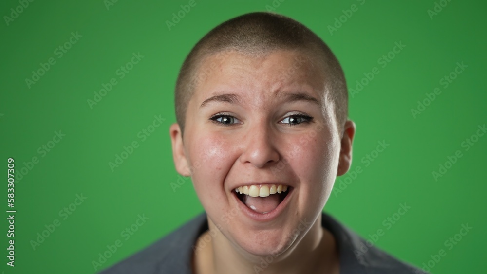 Slow motion closeup portrait of amazed non binary gender fluid woman 20s shocked, saying WOW. Pretty female surprised isolated on solid green screen background.