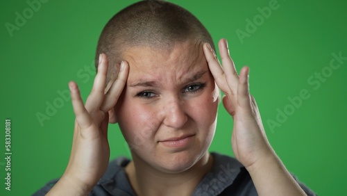 Sick tired headache migraine exhausted displeased gender fluid, non binary woman 20s posing isolated on green screen background studio. Put hands on head rub temples closeup slow motion