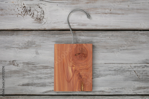 Isolate aromatic cedar block with a hanger on white wood background. photo