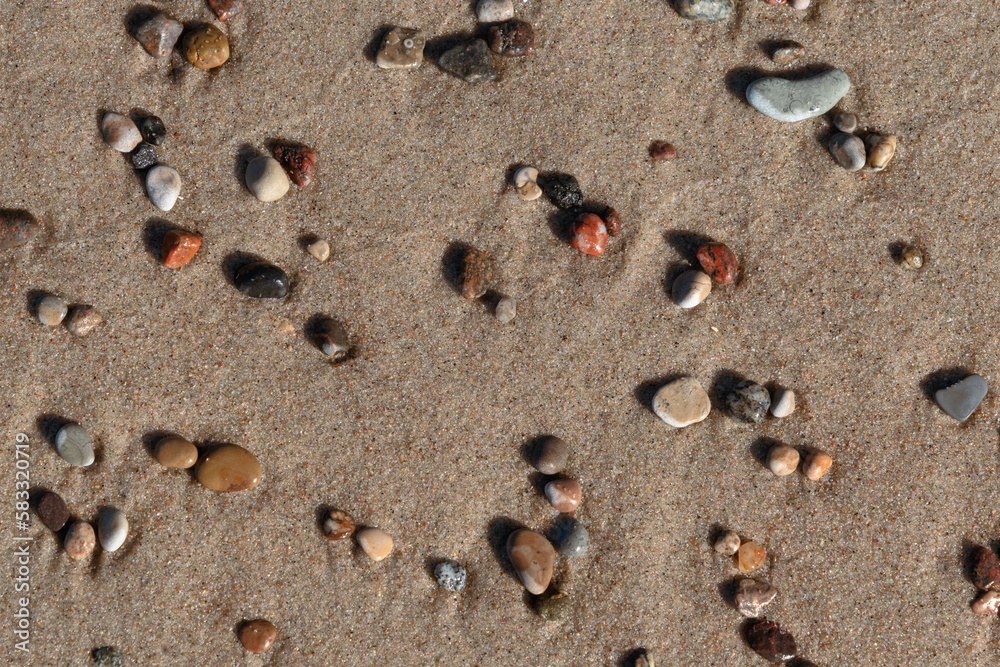 Colorful sea pebbles on the sand of the beach on the Baltic Sea, Curonian Spit, Kaliningrad region, Russia
