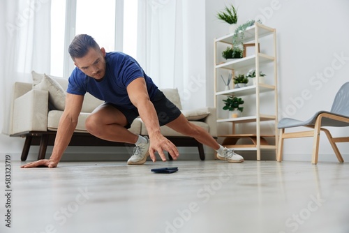 Man sportsman training at home, stretching exercises for arm, leg and back muscles, strong body and correct posture, the concept of health and beauty
