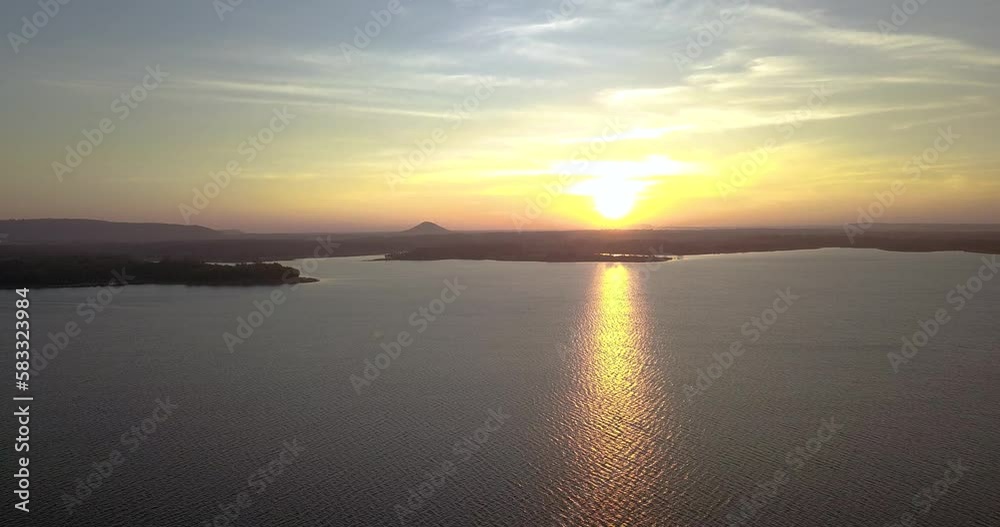 High angle drone flying of beautiful sunset over the river, golden sun over the mountains, Dramatic shining yellow in the sky, cloud sunset sky. High angle drone flying of beautiful sunset over the river, golden sun over the mountains, Dramatic shining yellow in the sky, cloud sunset sky.