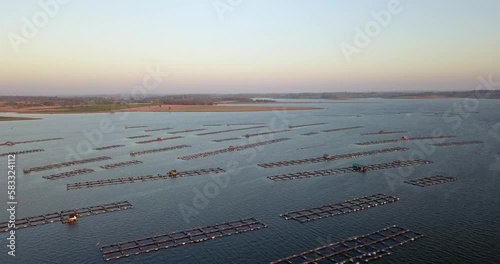 Aerial view of fish farm with cages for fish and shrimp in the lake, Top view, Thepsuda Bridge, Kalasin Province, Thailand. photo