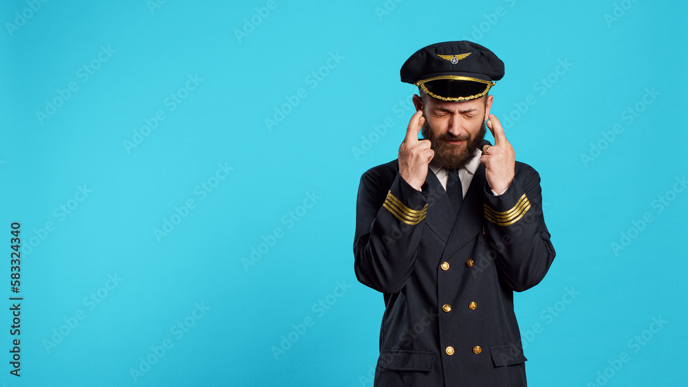 Hopeful airplane pilot posing with fingers crossed to fulfill wish, preparing for commercial flight work. Cabin captain praying for luck and fortune, acting wishful and having beliefs. Hopeful airplane pilot posing with fingers crossed to fulfill wish, preparing for commercial flight work. Cabin captain praying for luck and fortune, acting wishful and having beliefs.