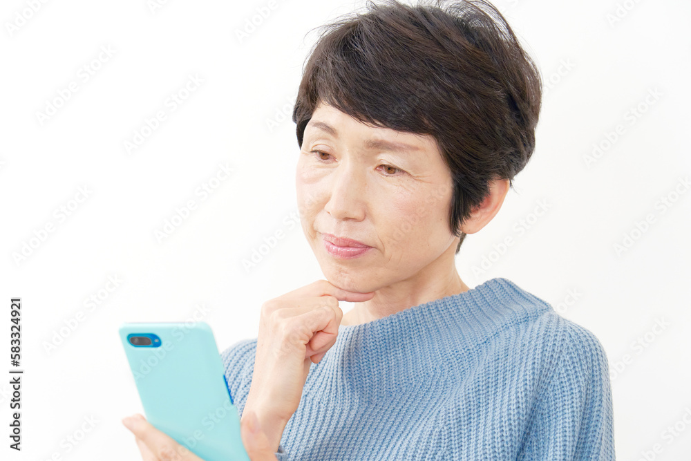 スマホを持って考える中年女性　白背景