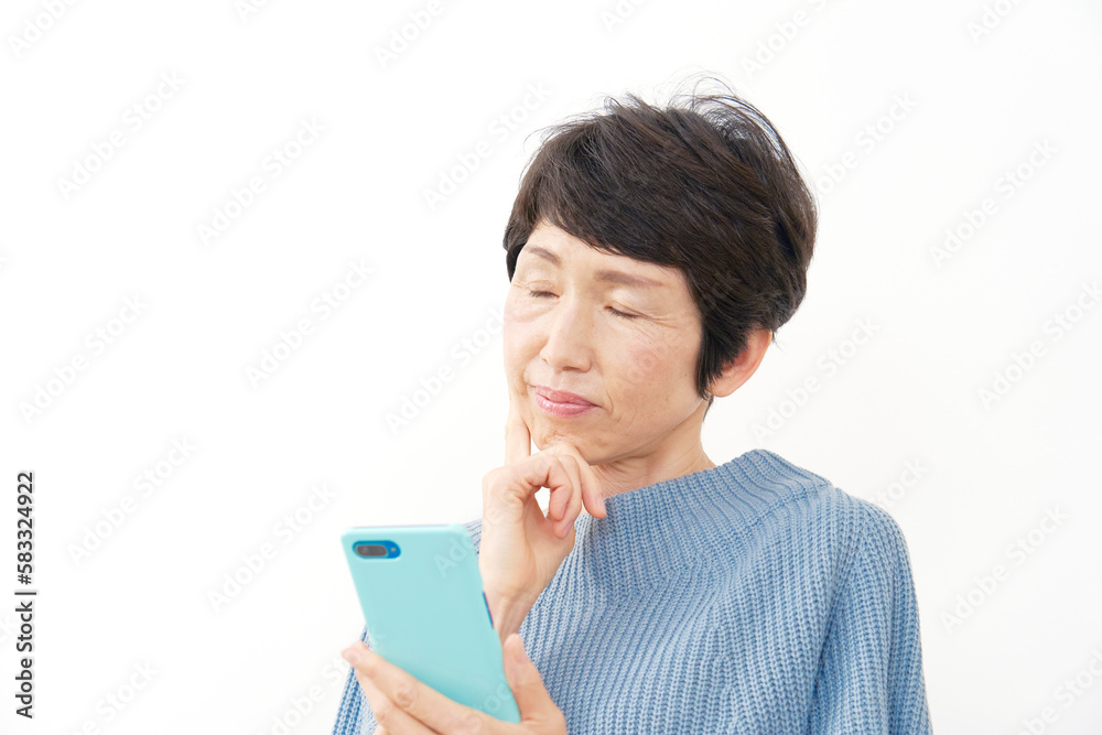 スマホを持って考える中年女性 白背景 スマホを持って考える中年女性 白背景