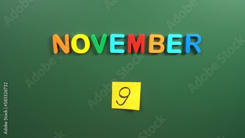 Hand sticking a sticker 9 November calendar day on school board. 9 date of November. Ninth day of November. 9th date number. 9 day calendar. Nine date. Pakistan Iqbal photo