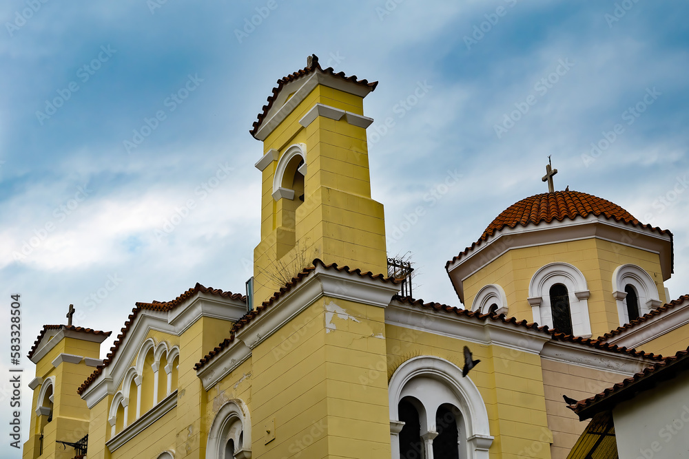 Yellow church against a cloudy blue sky
