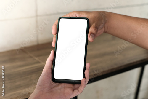 Mockup image of a woman showing mobile phone with blank white screen to someone © Sewupari Studio