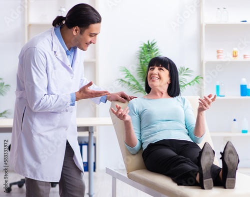 Old woman visiting young doctor dentist