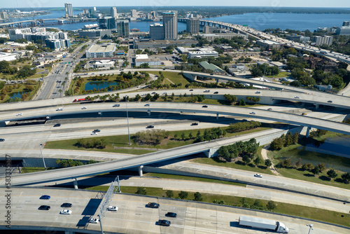 Photography Aerial view of freeway overpass junction with fast moving traffic cars and trucks