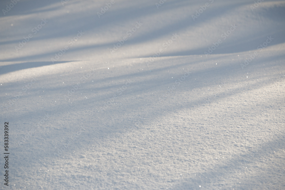Lines of shadow and light on fresh white morning snow abstract background
