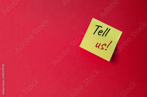 Tell us symbol. Orange steaky note with words Tell us. Beautiful red background. Business and Tell us concept. Copy space.