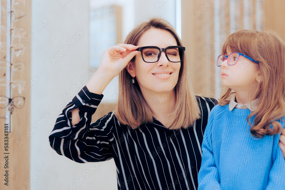 Obraz premium Mother and Daughter Wearing Eyeglasses in an Ophthalmology Clinic. Mom and child choosing stylish frames to wear in optical store 
