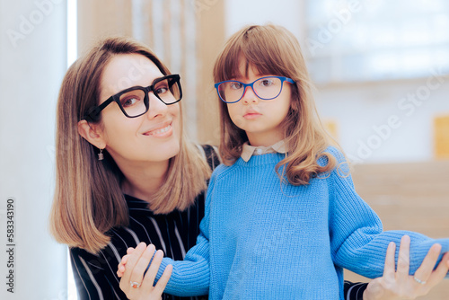 Mother and Daughter Wearing Eyeglasses in an Ophthalmology Clinic. Mom and child choosing stylish frames to wear in optical store
